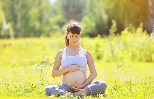 Pregnant woman sitting outdoors to illustrate fertility acupuncture