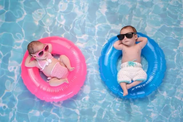 boy or girl baby concept with two infants in pink and blue floats