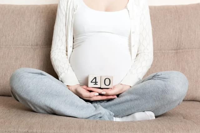 having a baby at 40 with pregnant woman holding number blocks showing age
