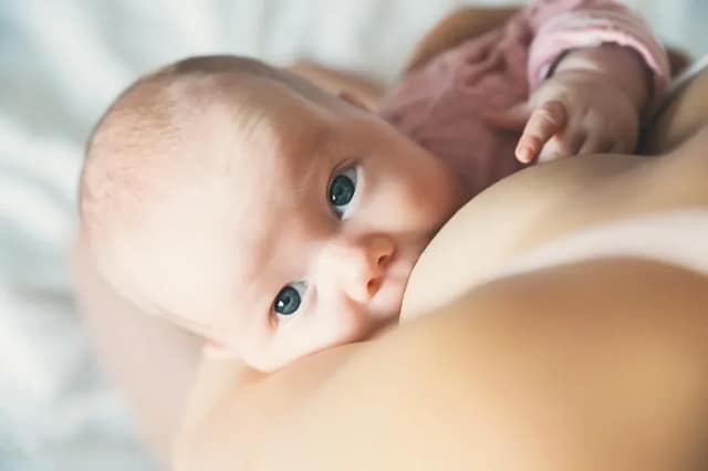 breastfeeding advice with close-up of a baby breastfeeding peacefully in a calm home setting