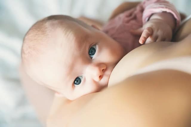 breastfeeding advice with close-up of a baby breastfeeding peacefully in a calm home setting