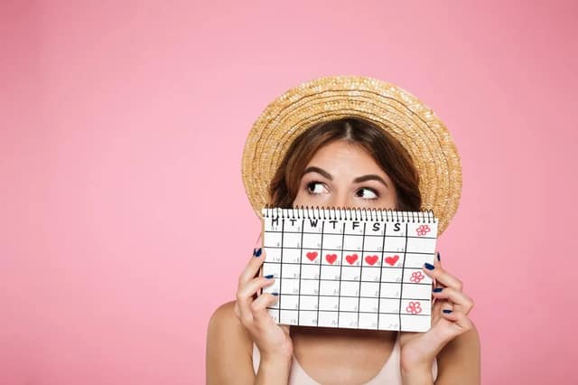 Woman holding a menstrual calendar and wondering if she can get pregnant on period