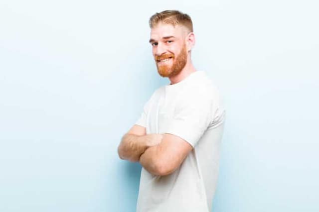 Young red-haired man smiling at camera representing potential free sperm donor available for co-parenting arrangement