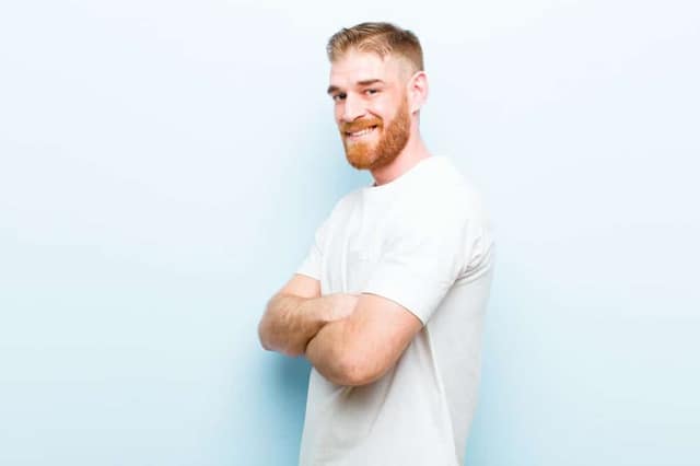 Young red-haired man smiling at camera representing potential free sperm donor available for co-parenting arrangement
