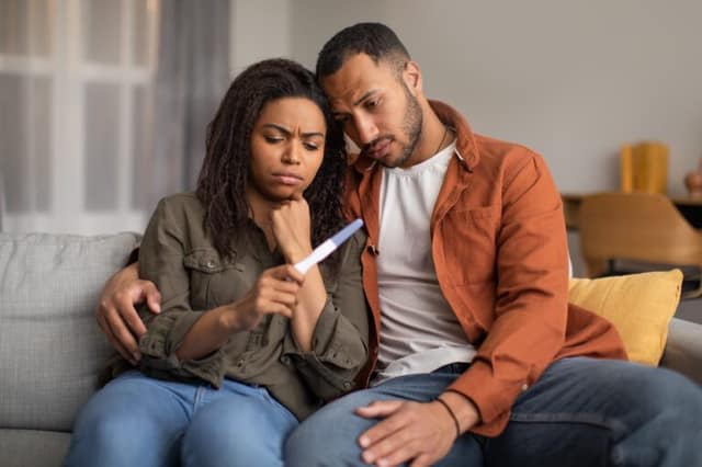 Causes of infertility concept showing couple with negative pregnancy test and emotional distress