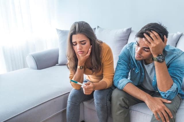 Sad couple seeking infertility support after a negative pregnancy test