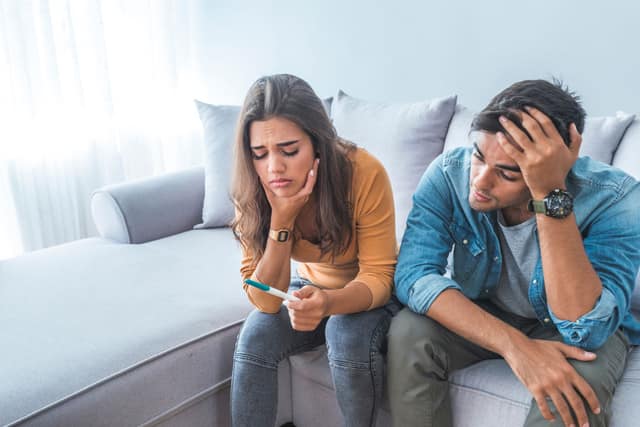 Sad couple seeking infertility support after a negative pregnancy test
