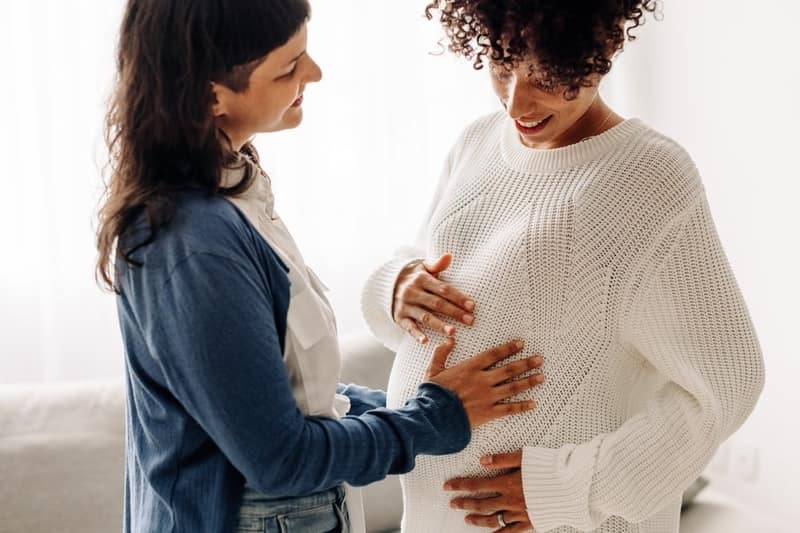 happy young woman touching surrogate mothers