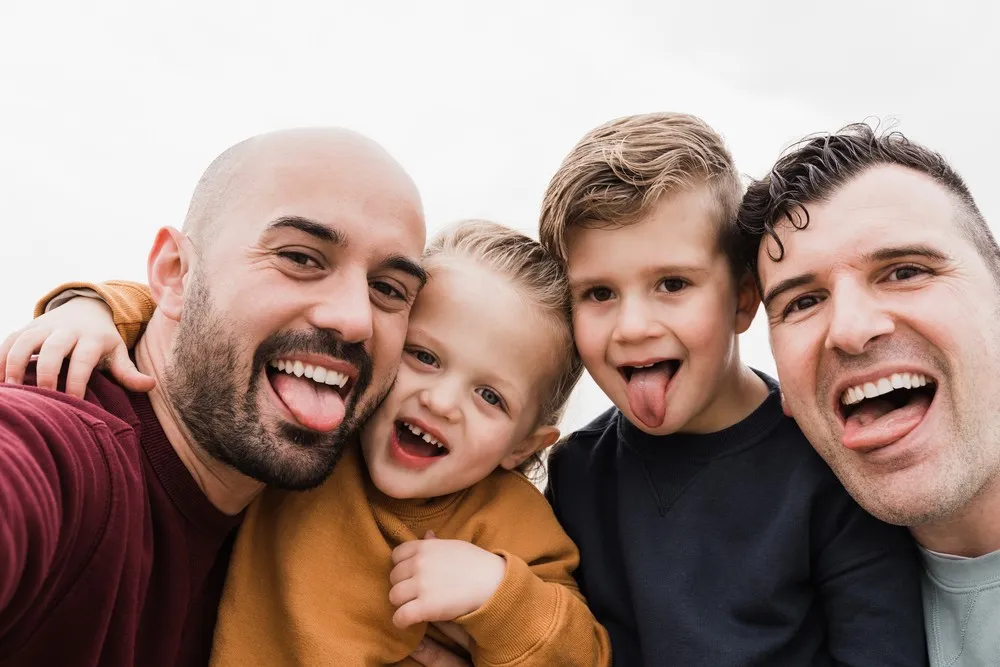 Being a gay dad same-sex fathers with children smiling and having fun together