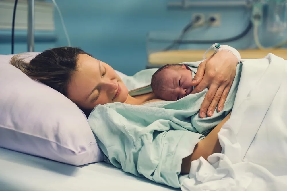 Register birth UK mother holding newborn baby in hospital