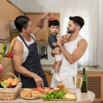 same sex parenting with two fathers caring for their baby in the kitchen